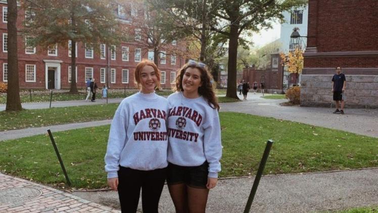 two female students standing together at a university campus